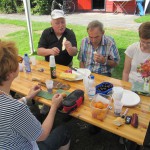 Personen an Biertisch essen Obst